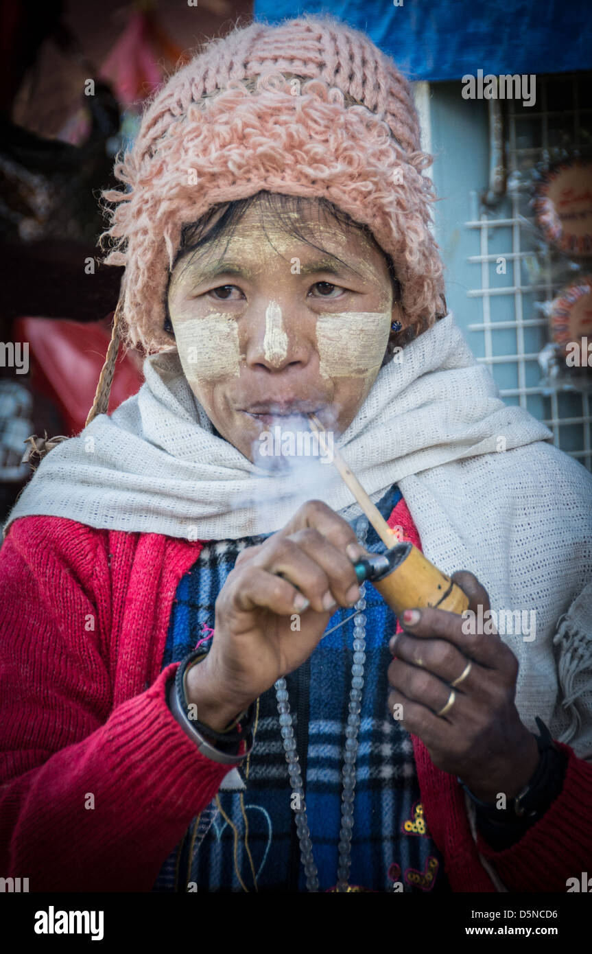 Frau Beleuchtung ihre Leitung in einem Markt, in Myanmar. Stockfoto