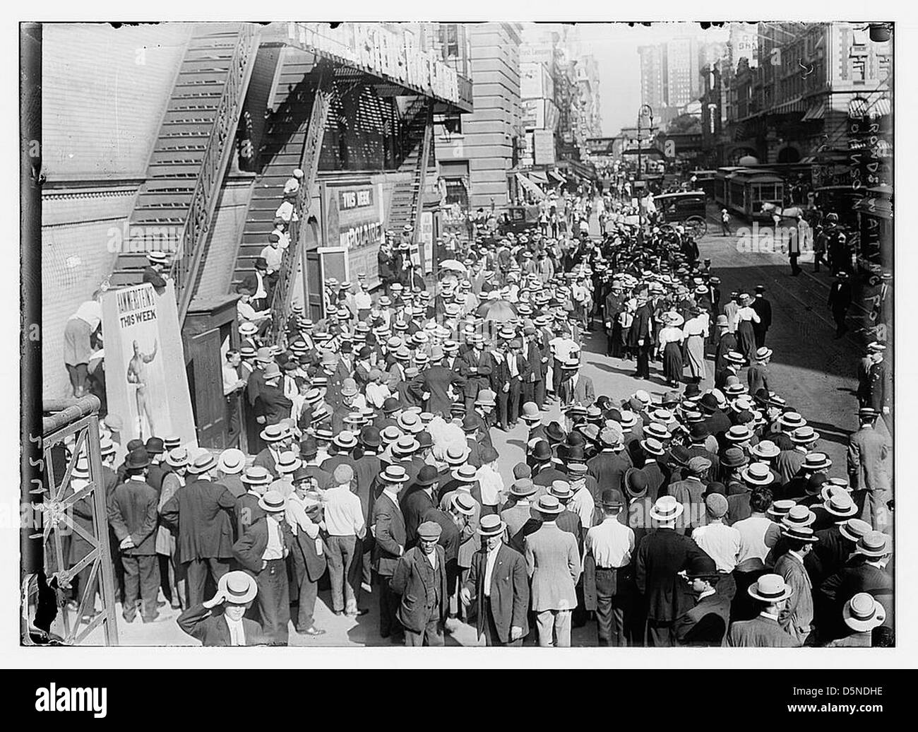 Dieses Foto zeigt eine große Menschenmenge, die sich 1910 vor Oscar Hammerstein's Theater in New York City versammelte und darauf wartete, einen Blick auf den berühmten Boxer Jack Johnson zu werfen. Die Menge repräsentiert eine Mischung aus Rassenspannungen und Berühmtheiten während dieser Ära. Stockfoto