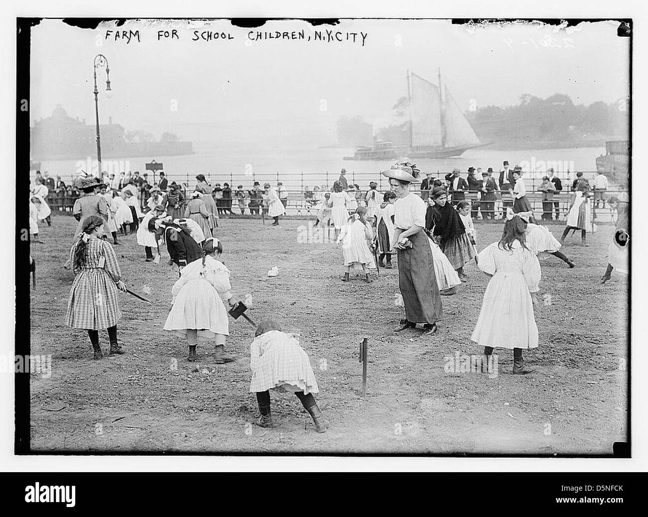 Eine Farm, die Anfang der 1910er Jahre für Schulkinder in New York City entworfen wurde, um Schüler über Landwirtschaft und ländliches Leben zu informieren. Das Bild zeigt Kinder in einem Boot mit einer Flusslandschaft, die landwirtschaftliche Bildungsprogramme aus dem frühen 20. Jahrhundert repräsentieren. Stockfoto Eine Farm, die Anfang der 1910er Jahre für Schulkinder in New York City entworfen wurde, um Schüler über Landwirtschaft und ländliches Leben zu informieren. Das Bild zeigt Kinder in einem Boot mit einer Flusslandschaft, die landwirtschaftliche Bildungsprogramme aus dem frühen 20. Jahrhundert repräsentieren. Stockfoto