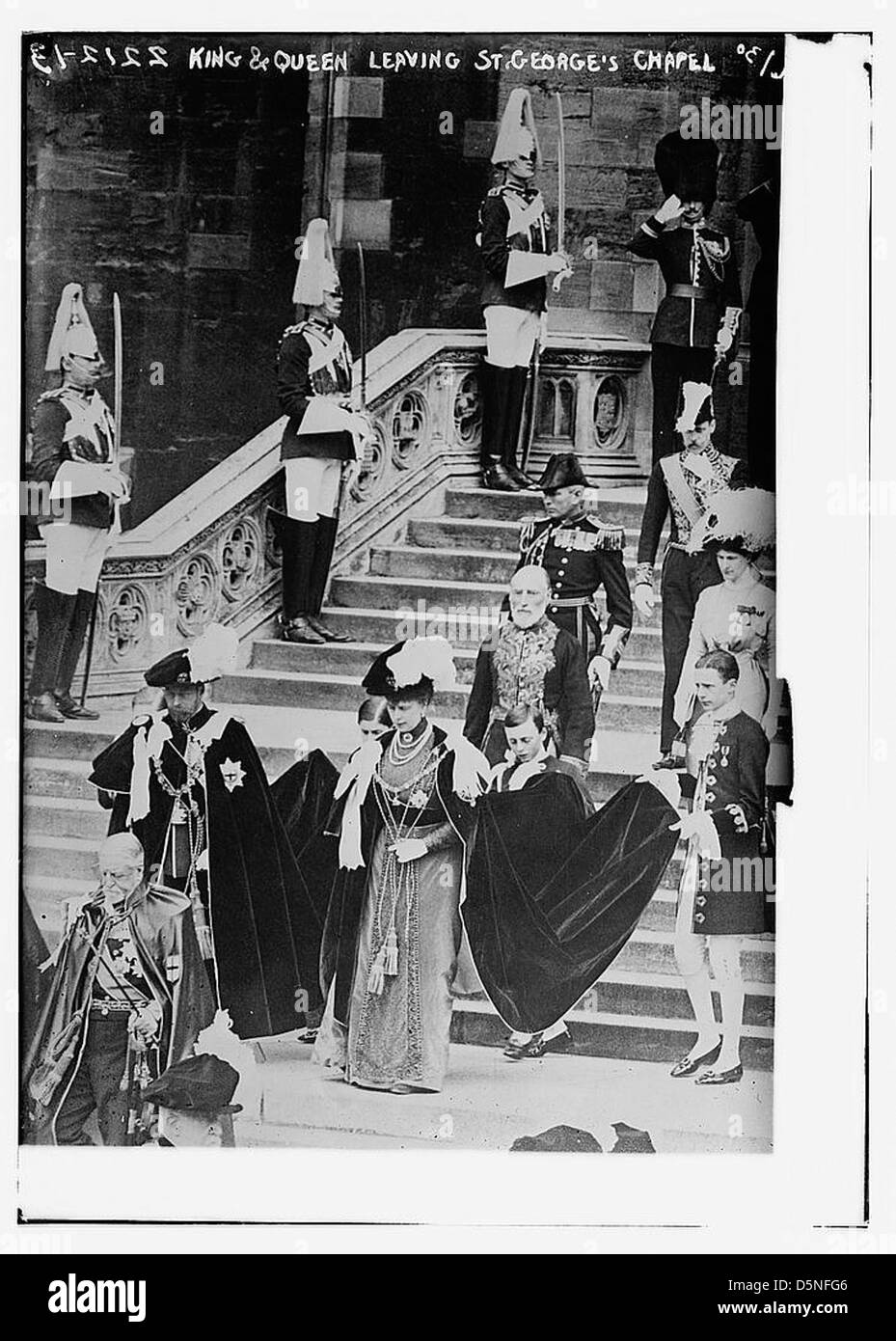 Ein historisches Foto von König Georg V. und Königin Maria, die die St. George's Chapel nach einer feierlichen Zeremonie in den 1910er Jahren verließen Das Bild fängt das königliche Paar in zeremoniellen Gewändern ein, wobei die Ehrenzeichen des Garterordens sichtbar sind. Stockfoto