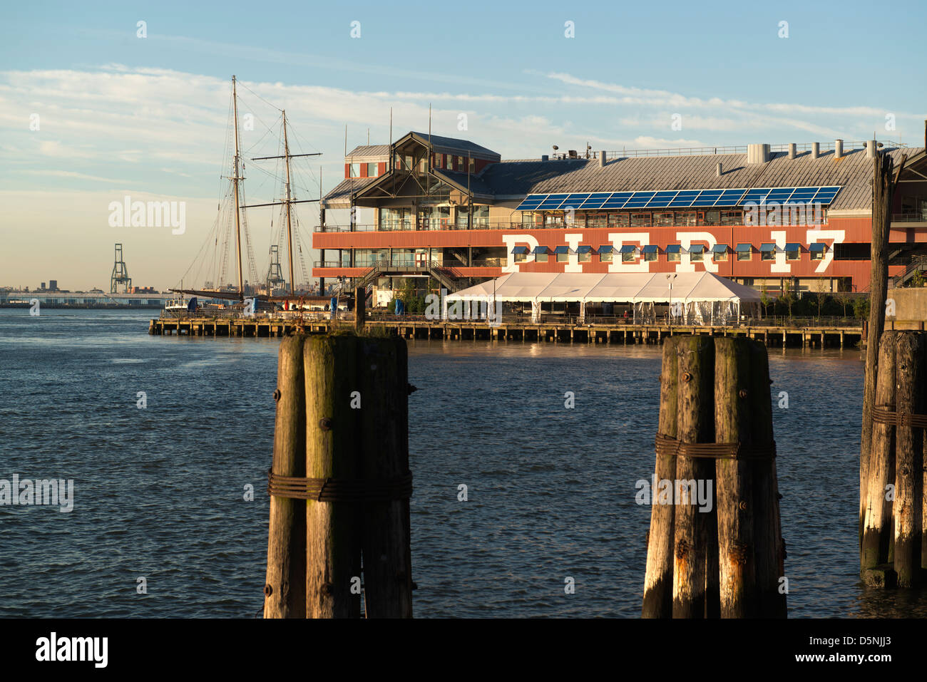 Pier 17, Teil des South Street Seaport mit alten Pylonen im Vordergrund. Stockfoto