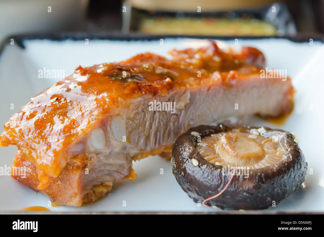 Nahaufnahme von Schweinefleisch Spareribs mit roter Soße und Pilzen Stockfoto