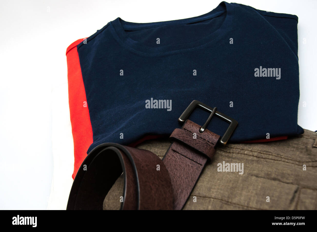 Mens Kleid Hose Hosen T Shirts und Gürtel auf weißen Hintergrund isoliert Stockfoto