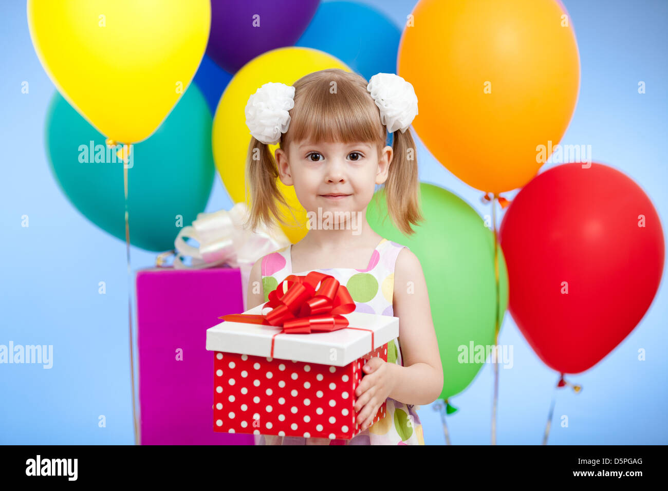 Niedliche Mädchen mit bunten Luftballons und Geschenken Stockfoto