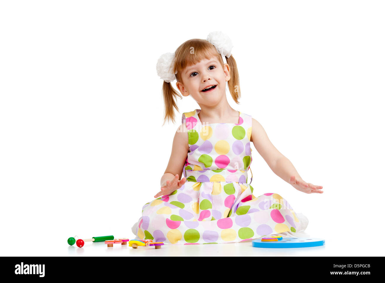 Lustige kleine Mädchen spielen mit Spielzeug, isoliert auf weiß Stockfoto