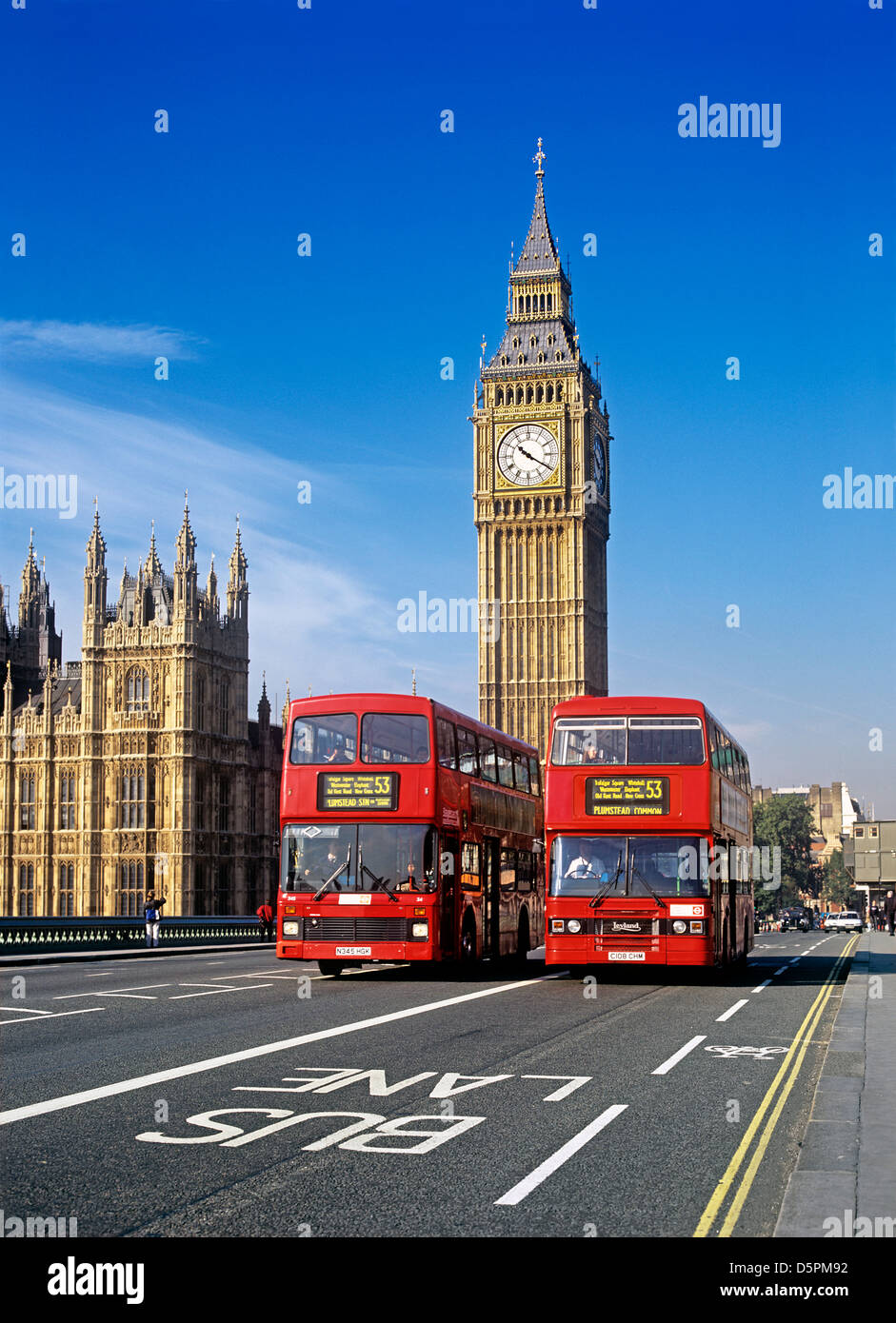 Busspur, Radweg und zwei Londoner Busse auf Westminster Bridge, London. Clock Tower Houses of Parliament im Hintergrund. Stockfoto