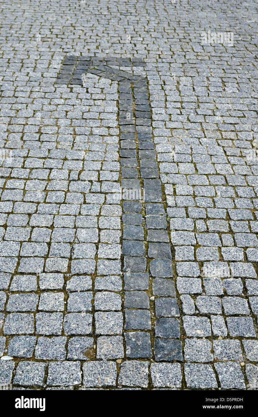 gepflasterte Straße mit Pfeil als Hintergrund Stockfoto