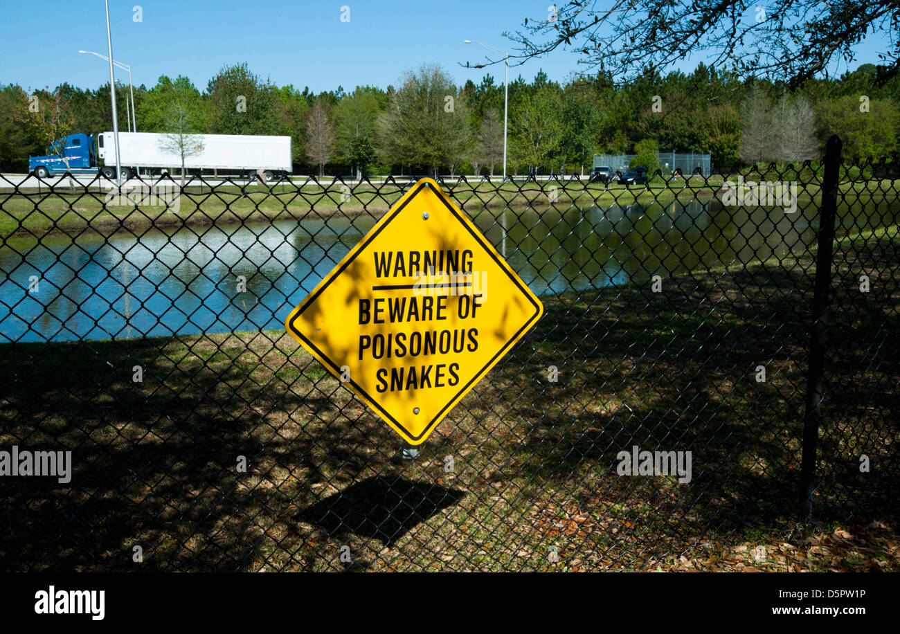 Das Schild sagt "Hüten Sie sich vor giftigen Schlangen" in der Nähe von I-95 in Nordflorida. Stockfoto