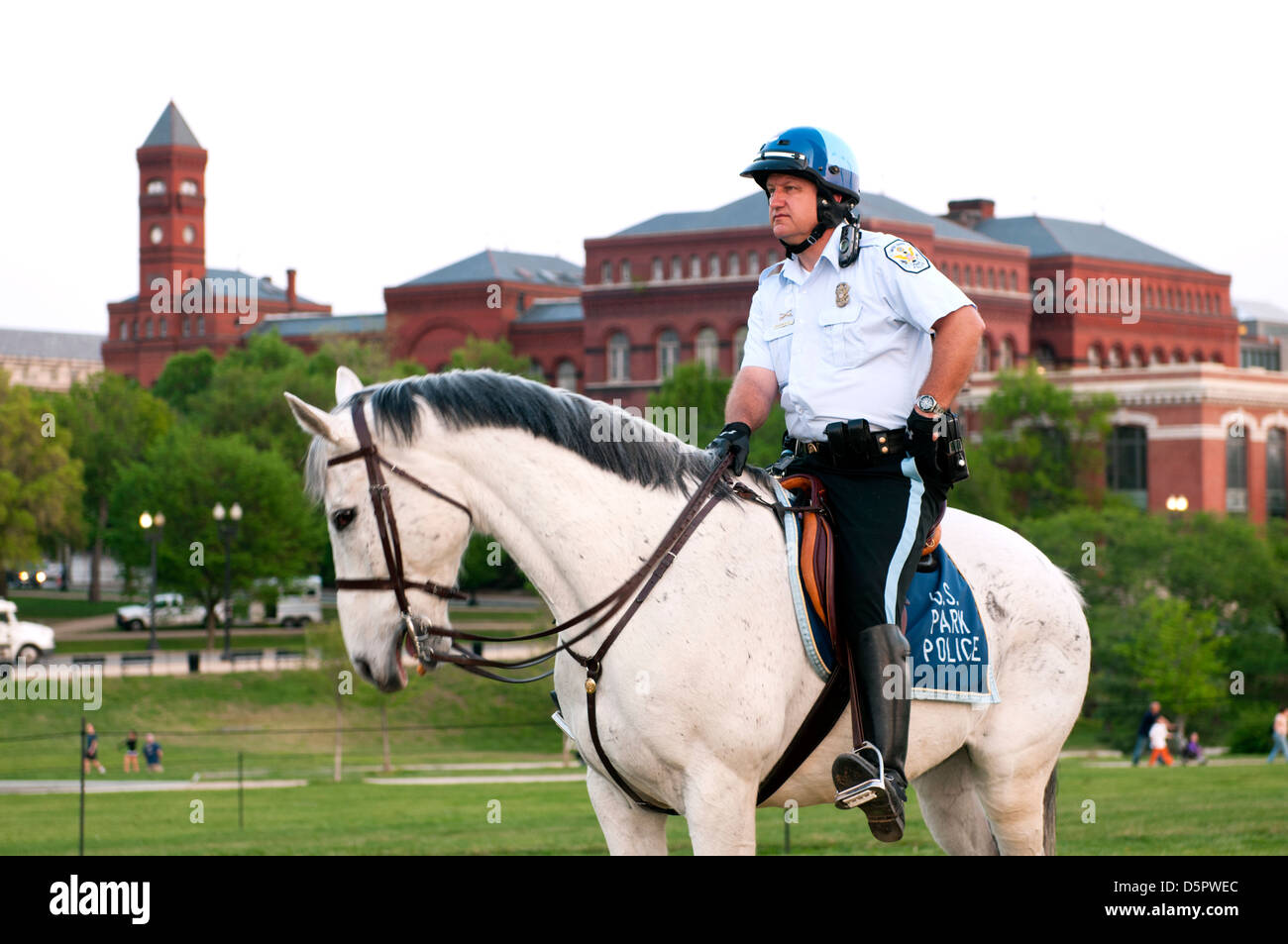 Ein Pferd montiert Polizist auf der National Mall in Washington DC mit der Smithsonian Institution in den Hintergrund. Stockfoto
