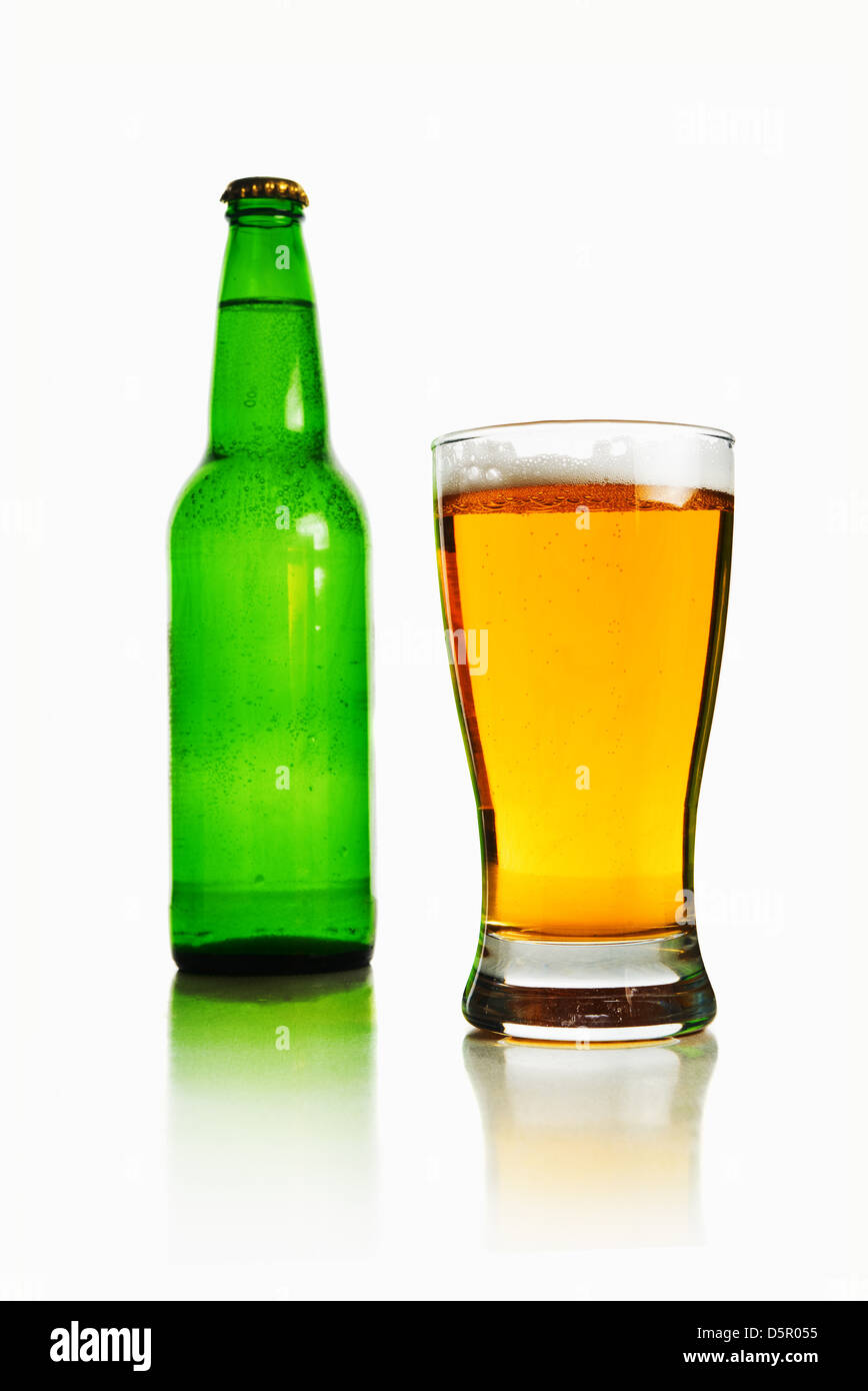 Bierflasche und Glas voller helles Bier auf einem weißen Hintergrund. Stockfoto