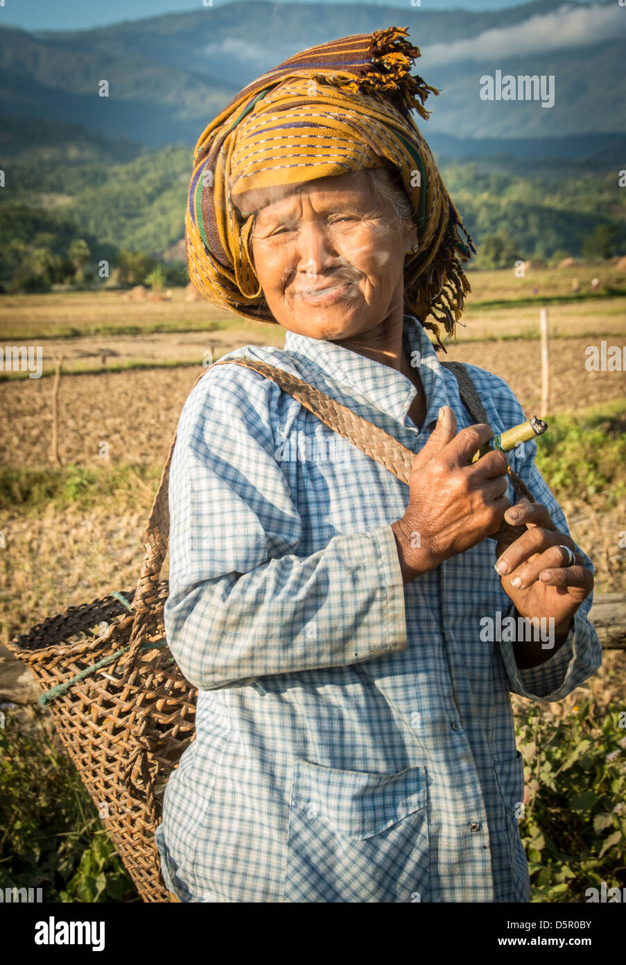 Frau landwirtschaftlicher Arbeitnehmer Rauchen einer Zigarre. Stockfoto