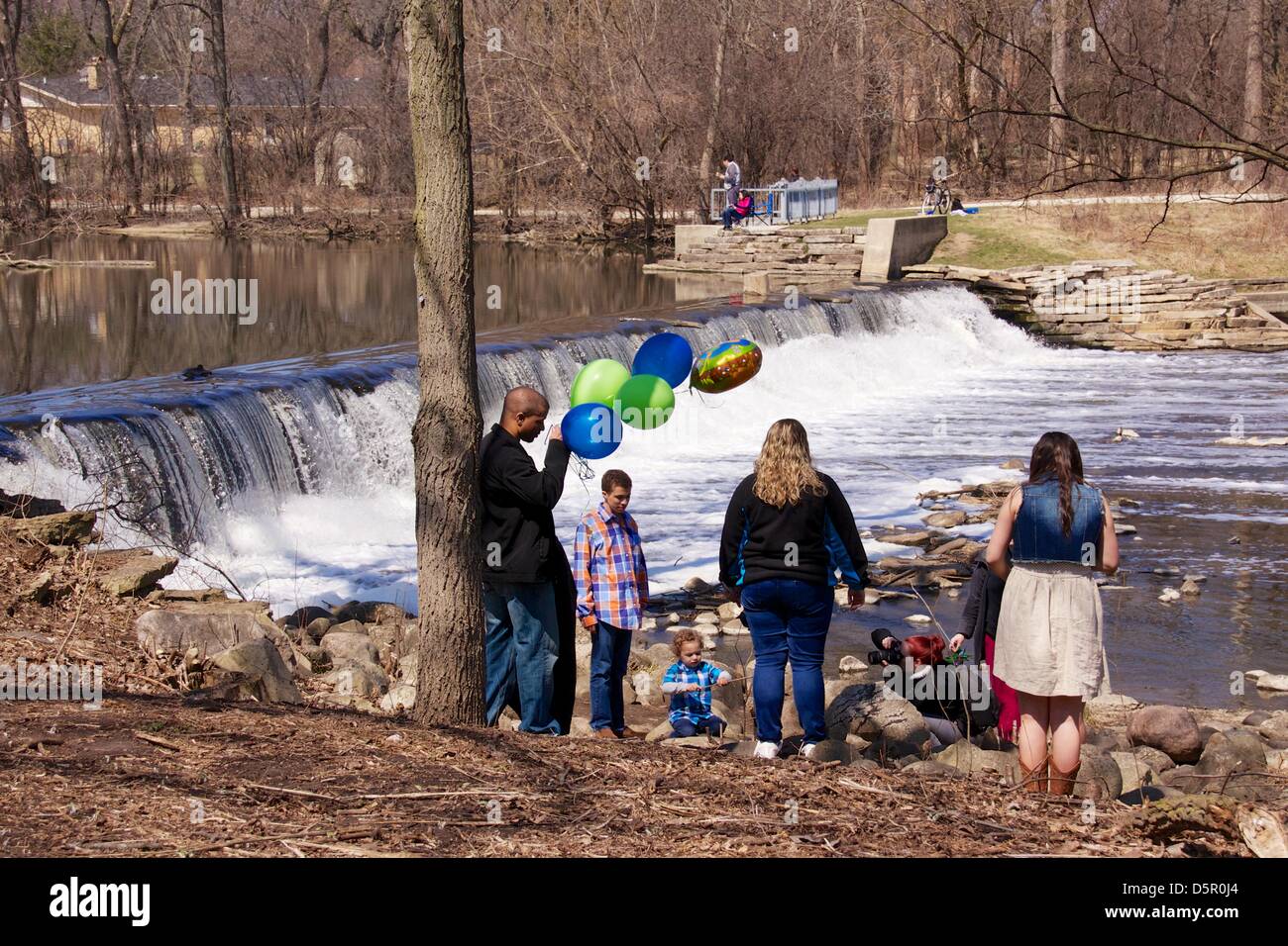 Oak Brook, Illinois, USA. 7. April 2013. Eine Familie genießt eine Foto-Session auf die Graue Mill Dam auf Salt Creek, wie Fischer ihr Glück, über den Bach versuchen. Viele Menschen wurden aus den warmen Tag in diesem malerischen Ort zu genießen. Bildnachweis: Todd Bannor / Alamy Live News Stockfoto