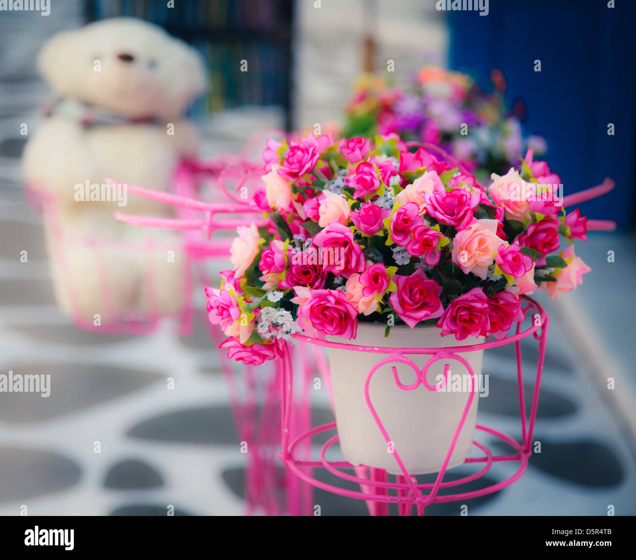 Künstliche Blumen in Vase mit verschwommen Puppe im Hintergrund, Vintage-look Stockfoto