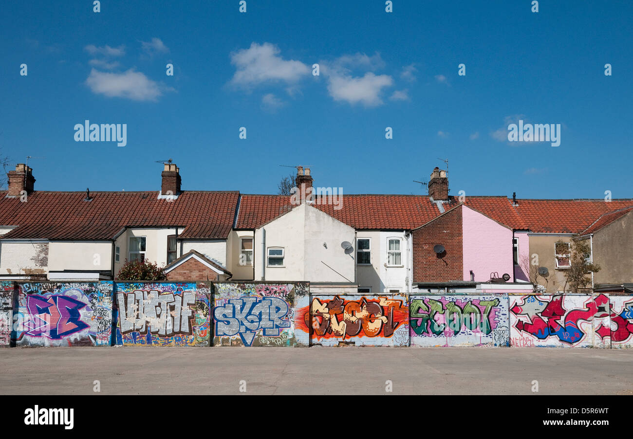 Reihe von Reihenhäusern mit Graffiti bedeckt wieder Gartenmauer Stockfoto