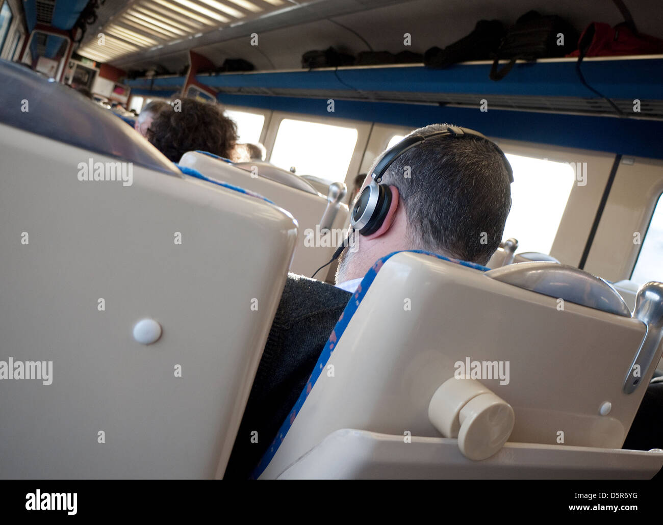 männlichen Passagier Zug mit Kopfhörern Stockfoto