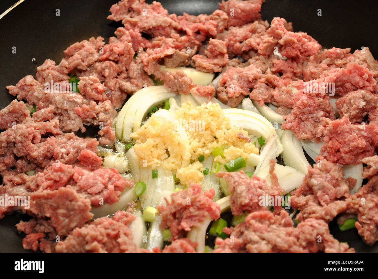 Gehacktes Rindfleisch mit Zutaten in einer Pfanne braten Stockfoto