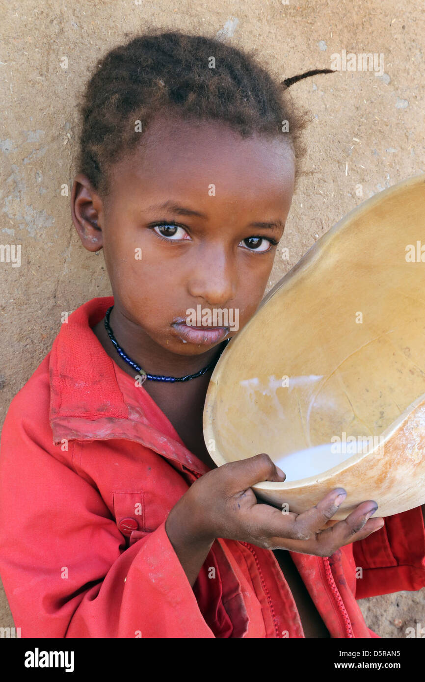 Mädchen trinkt Milch aus einer Kalebasse, Burkina Faso Stockfoto
