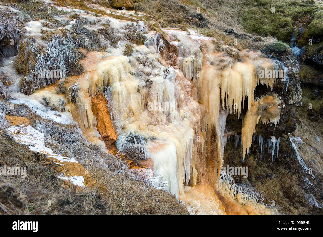 Wasserfall in den Farben von rostigen Eisen in Island im Winter gefroren Stockfoto