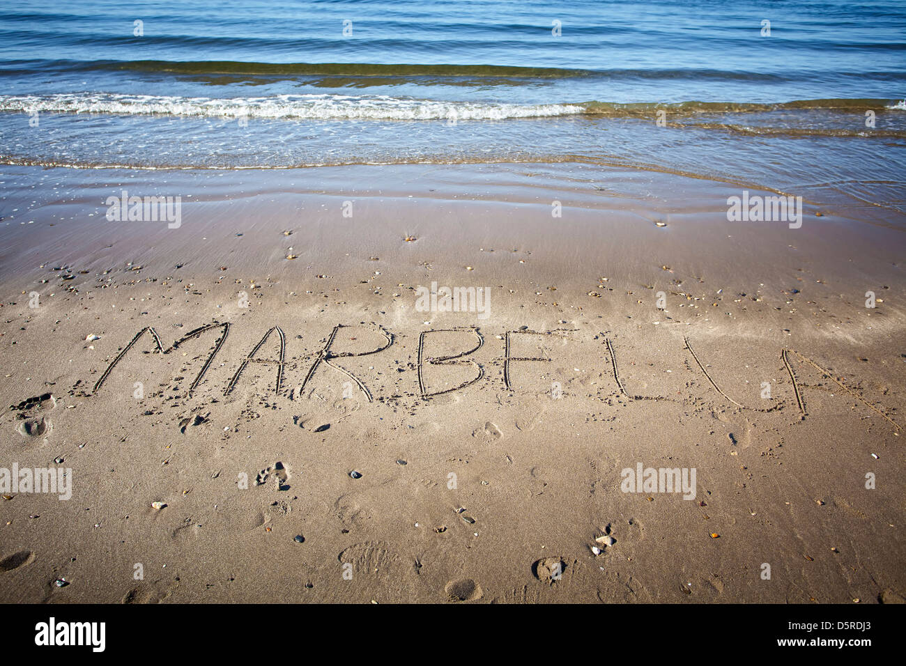 das Wort geschrieben im nassen Sand am Strand Marbella Stockfoto