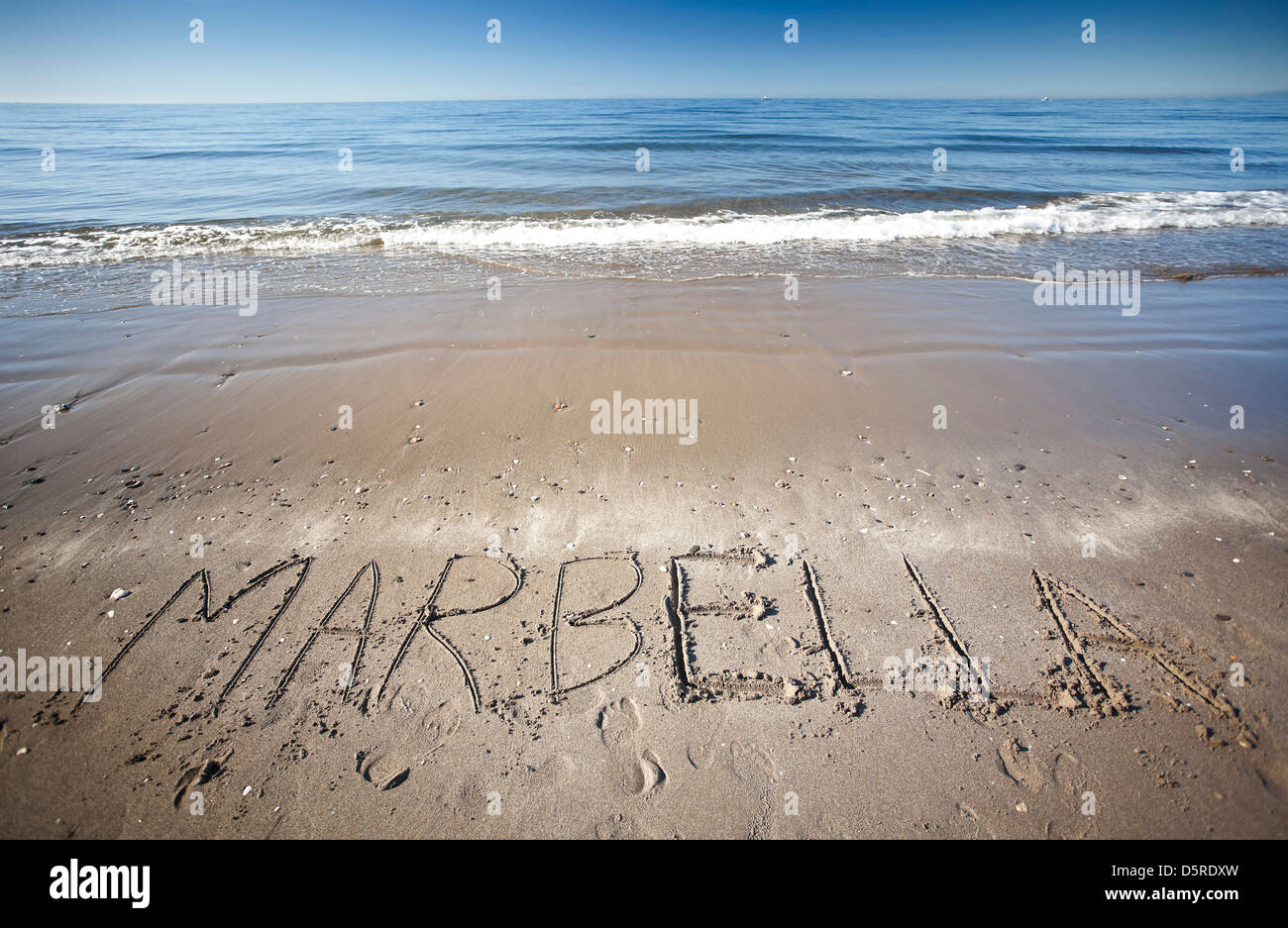 das Wort geschrieben im nassen Sand am Strand Marbella Stockfoto