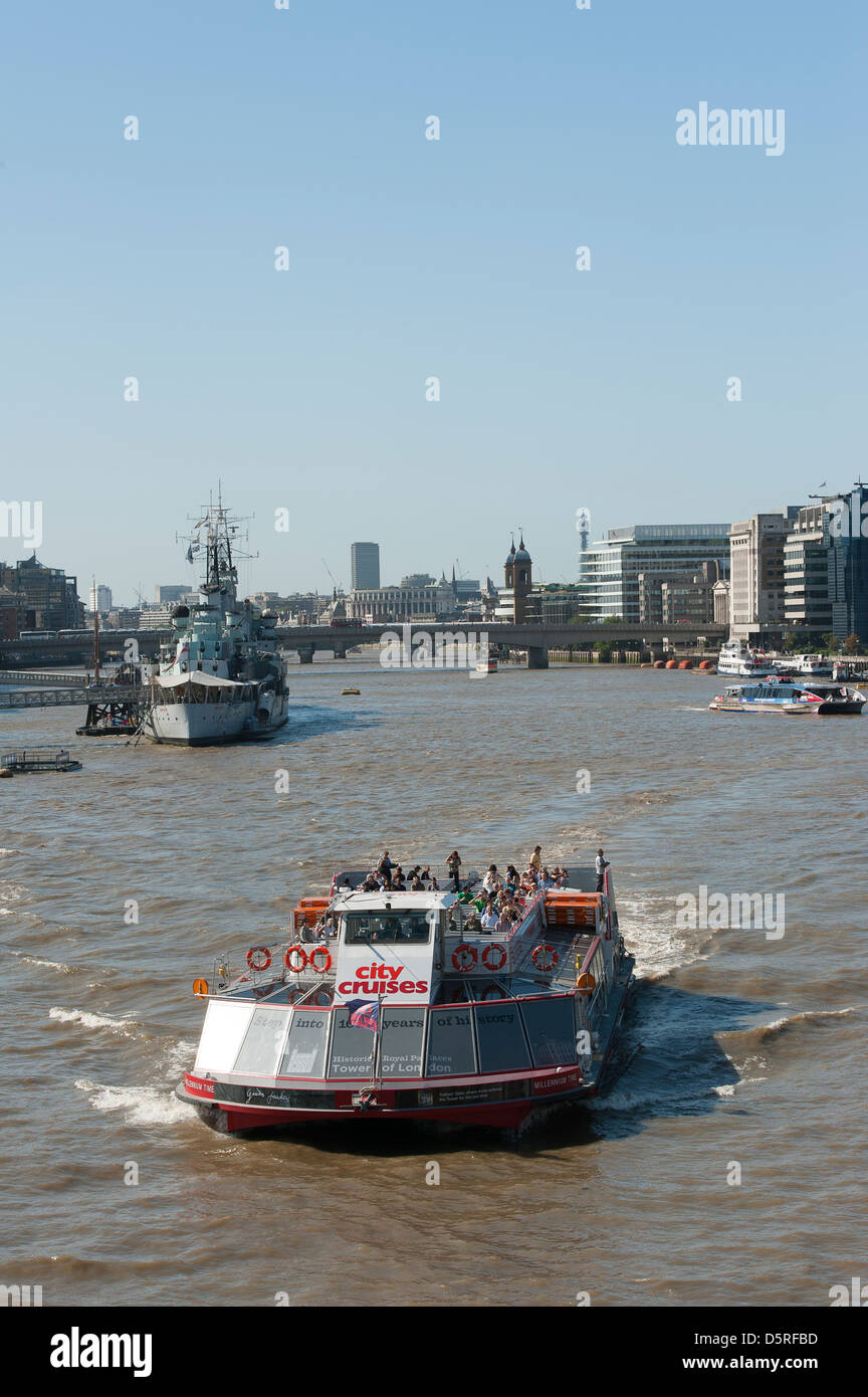 Stadt-Kreuzfahrt-Schiff mit Touristen vorbei HMS Belfast auf der Themse in London, England. Stockfoto