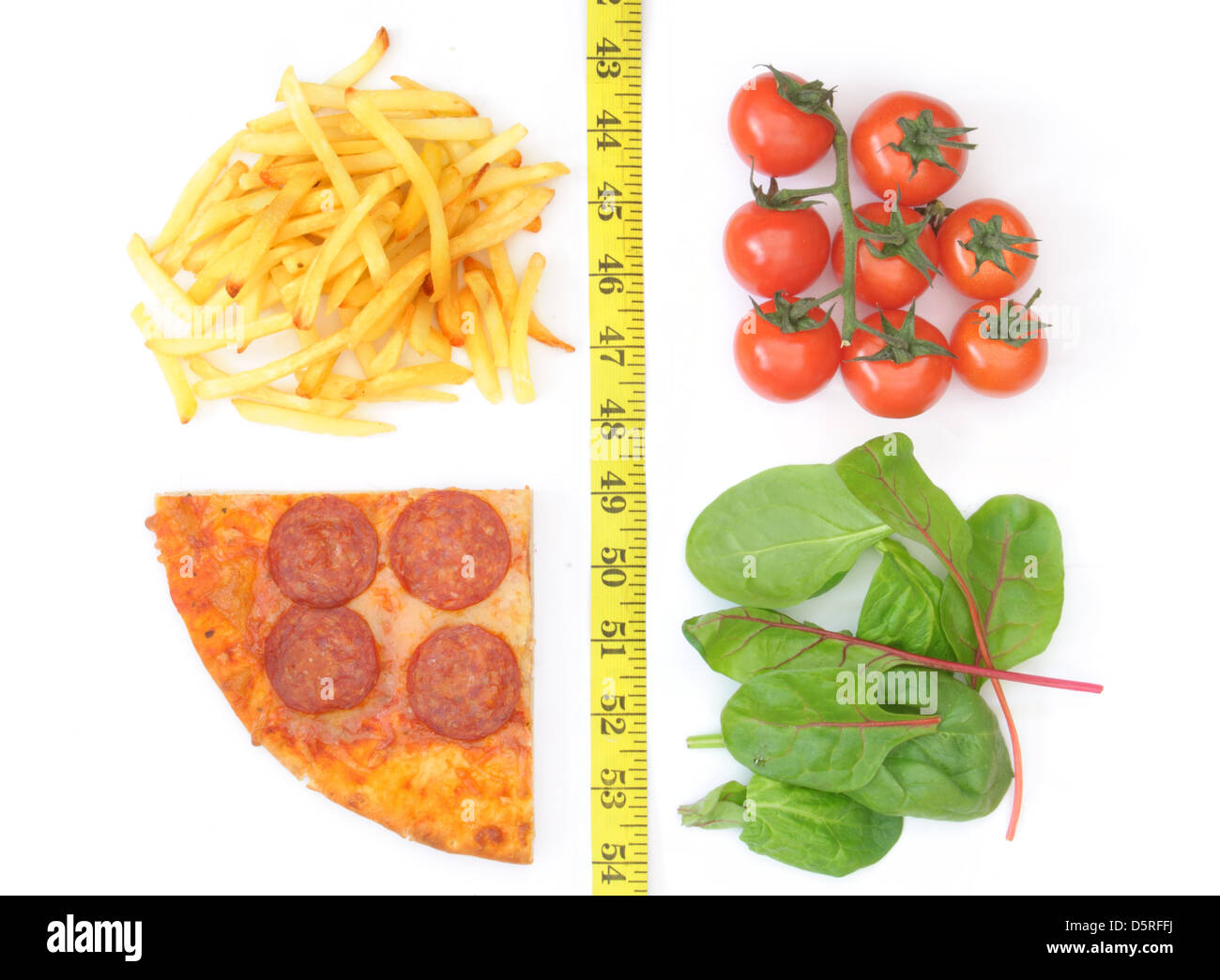 Gute und schlechte Ernährungsgewohnheiten getrennt mit einem Maßband. Französisch frites und Pizza auf der einen Seite, Tomaten und Salat auf der anderen Stockfoto