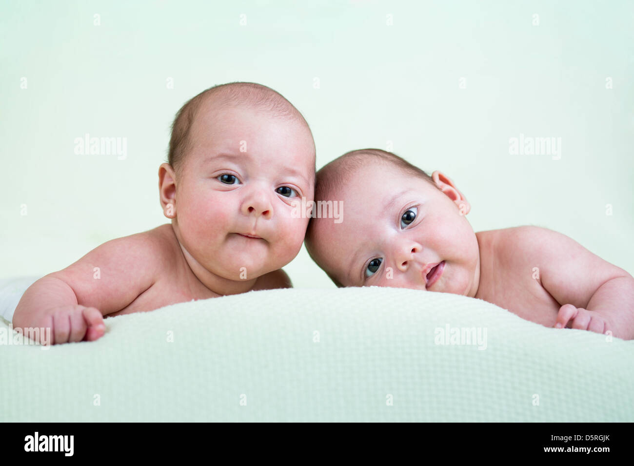 lustige neugeborenen Zwillinge auf Bauch liegend Stockfoto