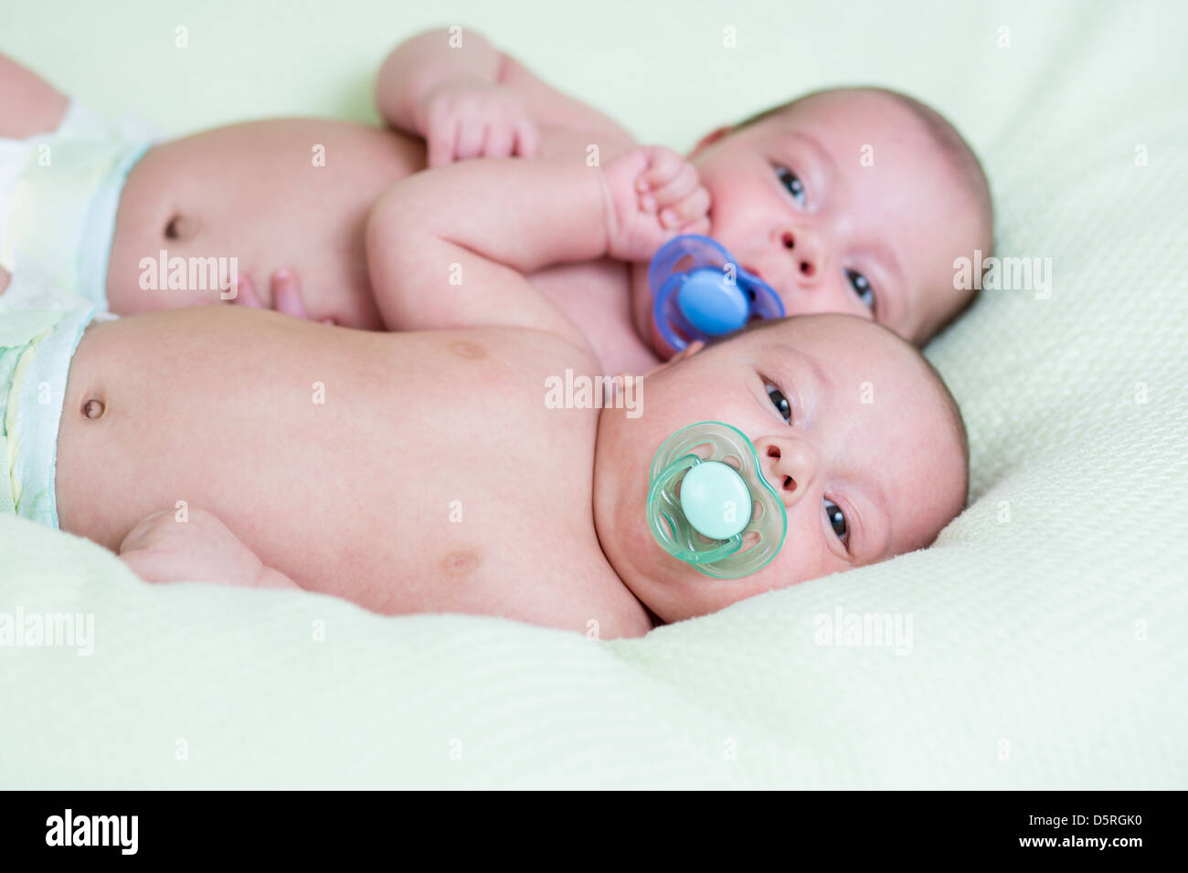 lustige neugeborenen Zwillinge liegen nebeneinander andere Stockfoto