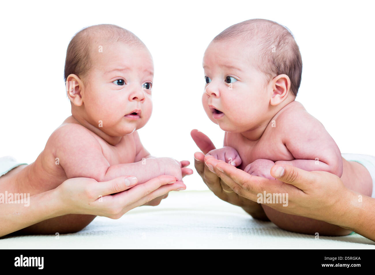 kleine Babys Zwillinge auf elterliche Hände isoliert auf weißem Hintergrund Stockfoto