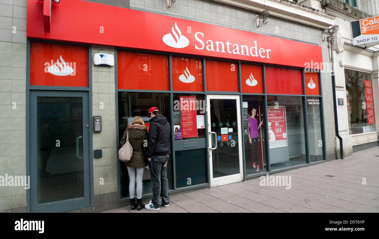 Junges Paar Leute mit der Santander Geldautomaten in der Queen Street, im Stadtzentrum von Cardiff Wales UK KATHY DEWITT erhalten Stockfoto