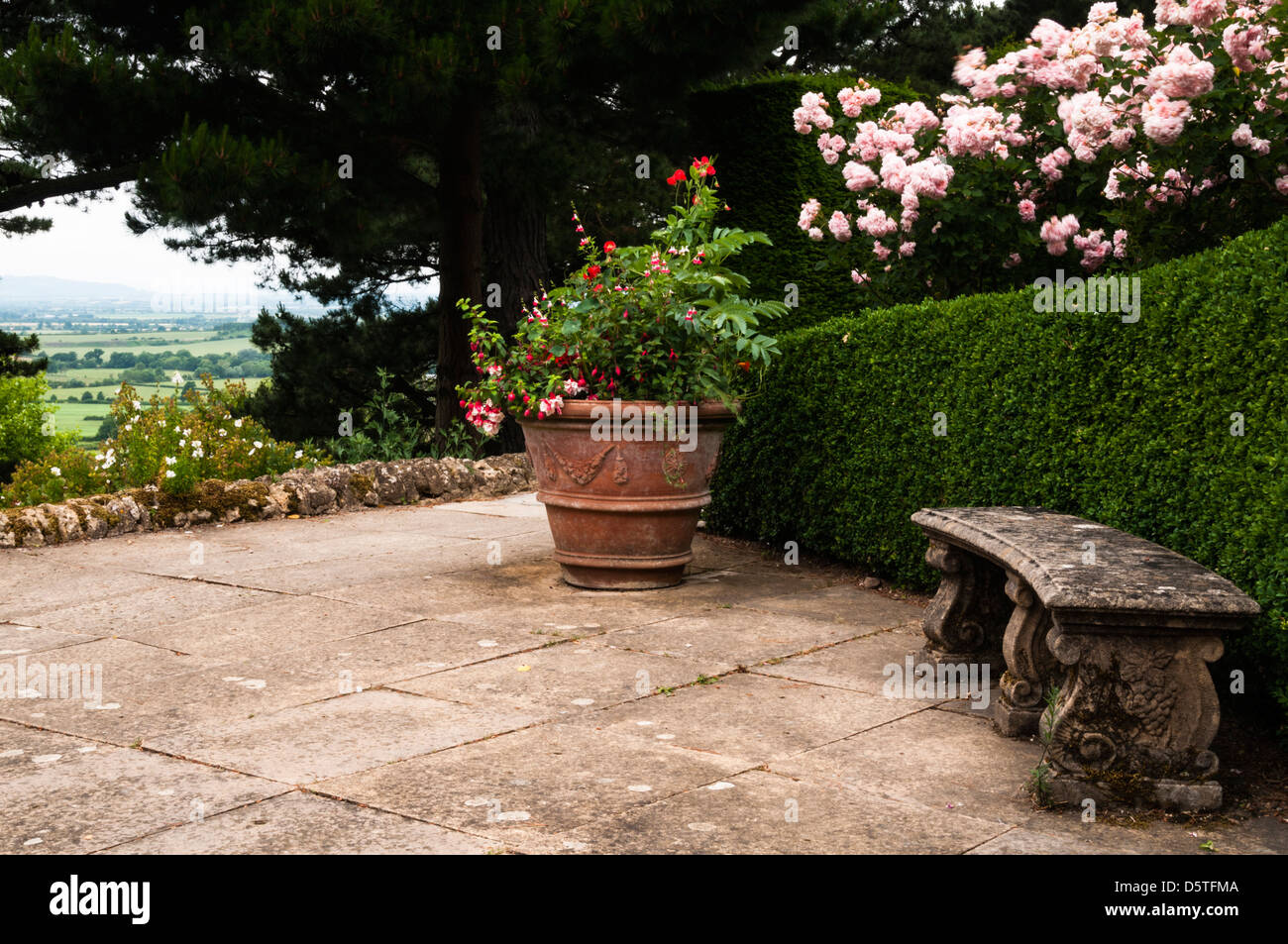 Eine Terrasse mit Blick auf die hügelige Landschaft der Cotswolds innerhalb Kiftsgate Court Gardens, Cotswolds, Gloucestershire, England Stockfoto