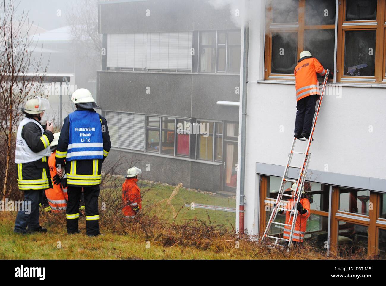 Feuerwehrleute löschen einen Brand in einer Behindertenwerkstatt in Titisee-Neustadt, Deutschland, 26. November 2012. Aus unklaren Gründen war ein Feuer in der Werkstatt ausgebrochen, 120 Menschen arbeiten deaktiviert. 14 Menschen starben im Feuer. Foto: Martin Ganz/Kamera TV24/Dpa Stockfoto