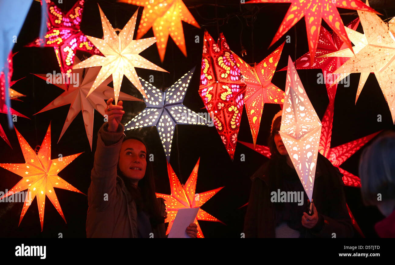 Eine Verkäuferin ordnet Sterne Lampions auf dem Weihnachtsmarkt am Gendarmenmarkt in Berlin, Germanym 26. November 2012. Foto: Wolfgang Kumm Stockfoto