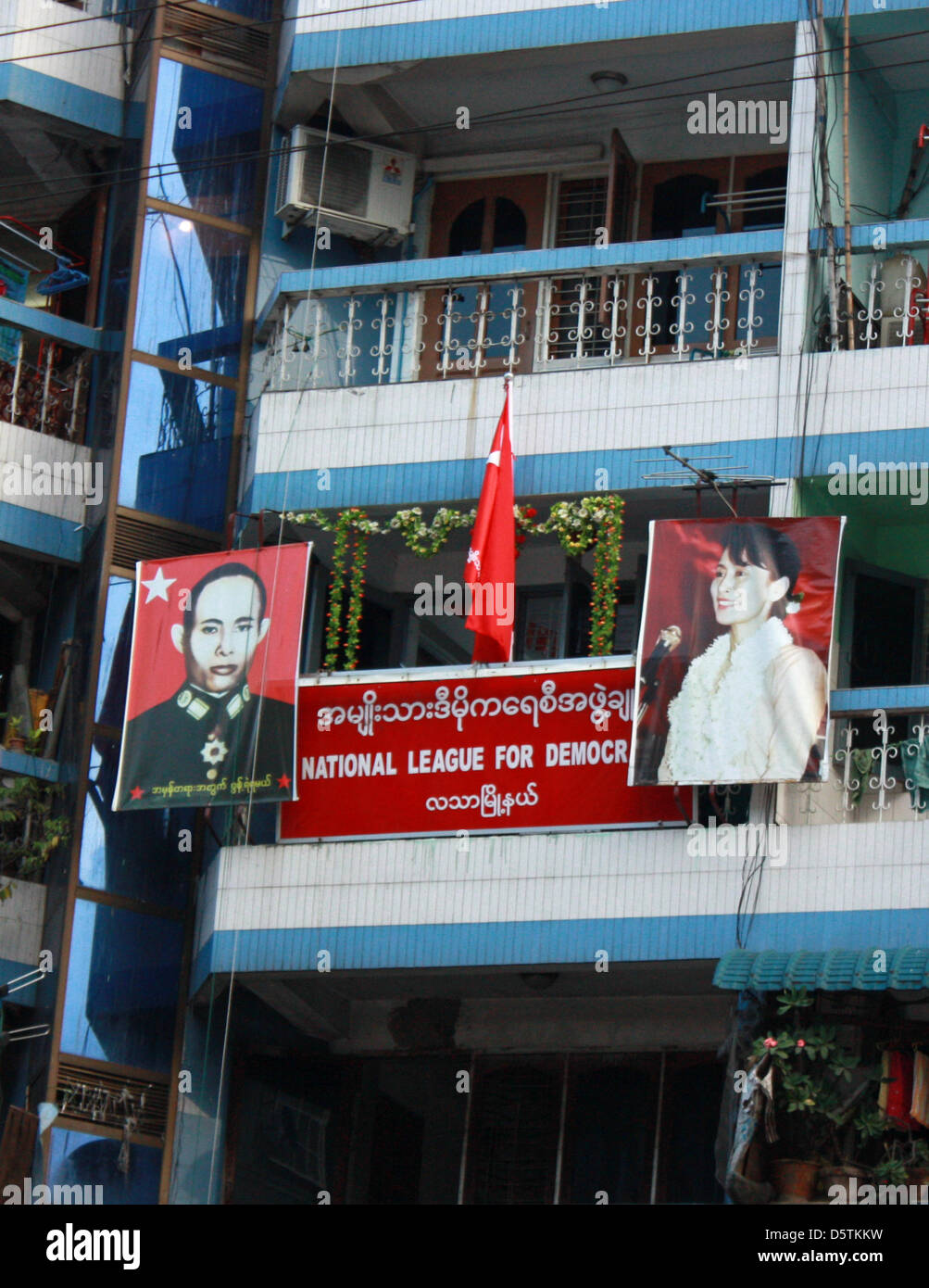 NLD-Pary-Büros sind Maha Bandoola unterwegs in Yangon, Myanmar, 21. Oktober 2012 abgebildet. Ein Bild des Oppositionsführers, Friedensnobelpreisträger und Vorsitzenden der Nationalliga für Demokratie (NLD), Aung San Suu Kyi (R) und ein Bild ihres Vaters Aung San, ehemaliger Kommandeur der Burma Independence Army, hängen von Ihrem Balkon aus. Foto: Rolf Zimmermann Stockfoto