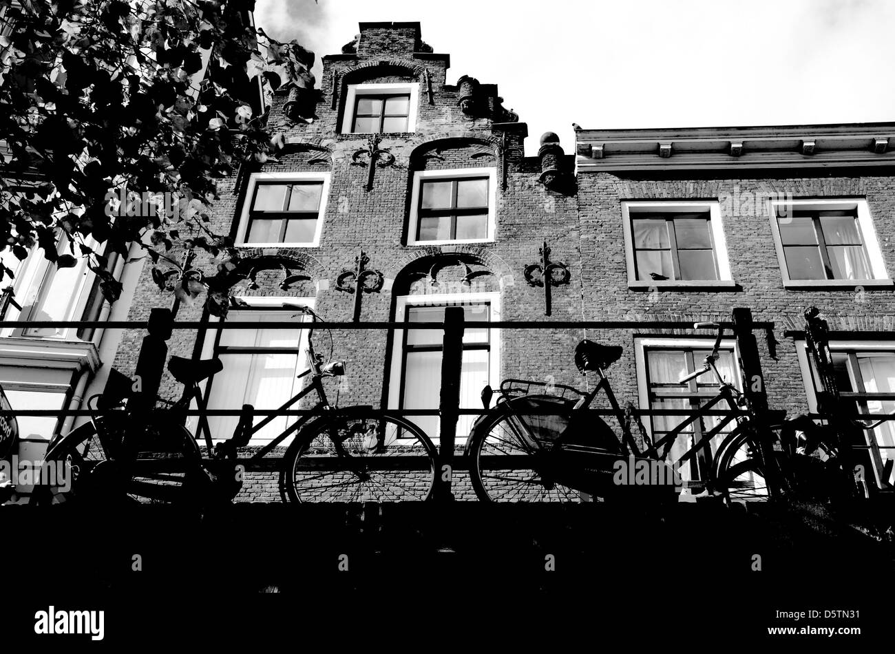 Fahrräder, die auf einer Brücke vor einem alten Kanalhaus geparkt, Oude Gracht, Utrecht, Niederlande Stockfoto
