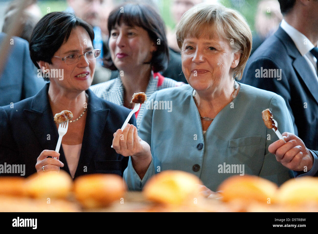 Thüringer Ministerpräsident Christine Lieberknecht (L) und die deutsche Bundeskanzlerin Angela Merkel Essen gegrillte Würstchen in Berlin, Deutschland, 24. September 2012. Die Thüringer Landesvertretung feierte ihr jährliche Festival mit mehr als 1.000 Gäste aus Wirtschaft und Politik. Foto: ROBERT SCHLESINGER Stockfoto