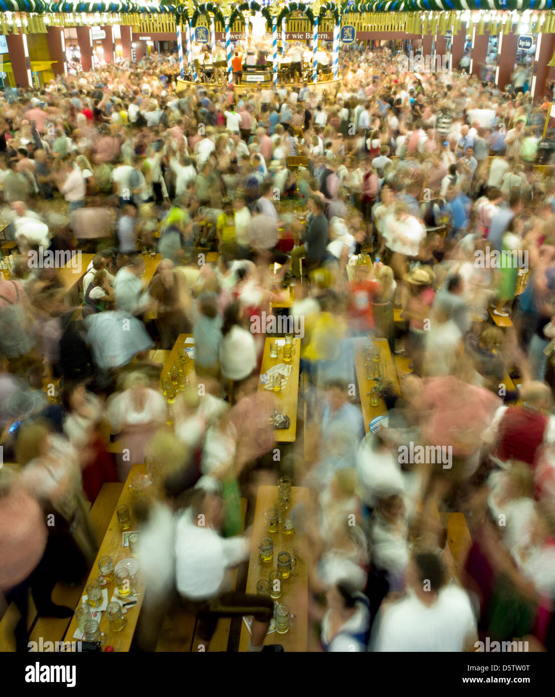 Besucher des Oktoberfestes wiegen die Musik an ihren Tischen Bier in München, Deutschland, 25. September 2012. (SECHS SEKUNDEN BELICHTUNGSZEIT). Das Oktoberfest gilt als die weltweit größte Messe und findet vom 22. September bis 7. Oktober 2012. Foto: PETER KNEFFEL Stockfoto