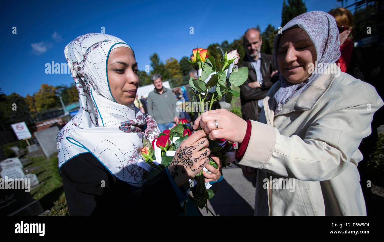 Frauen verteilen Blumen außerhalb der Sehitlik Moschee am Columbiadamm in Berlin, Deutschland, 3. Oktober 2012. 18 Moscheen haben ihre Türen für Besucher zum Tag der deutschen Einheit geöffnet. Foto: HANNIBAL Stockfoto