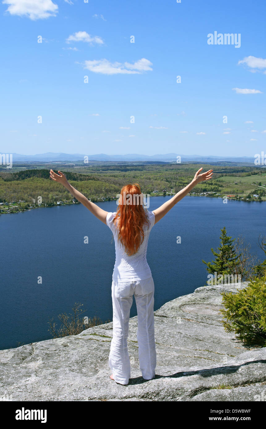 Glückliche Frau auf dem Berg bietet wunderschöne Aussicht. Stockfoto