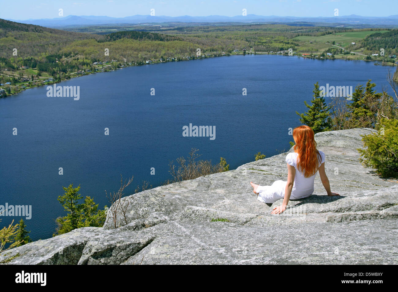 Junge Frau, die die Aussicht über den See vom Berg genießen. Stockfoto