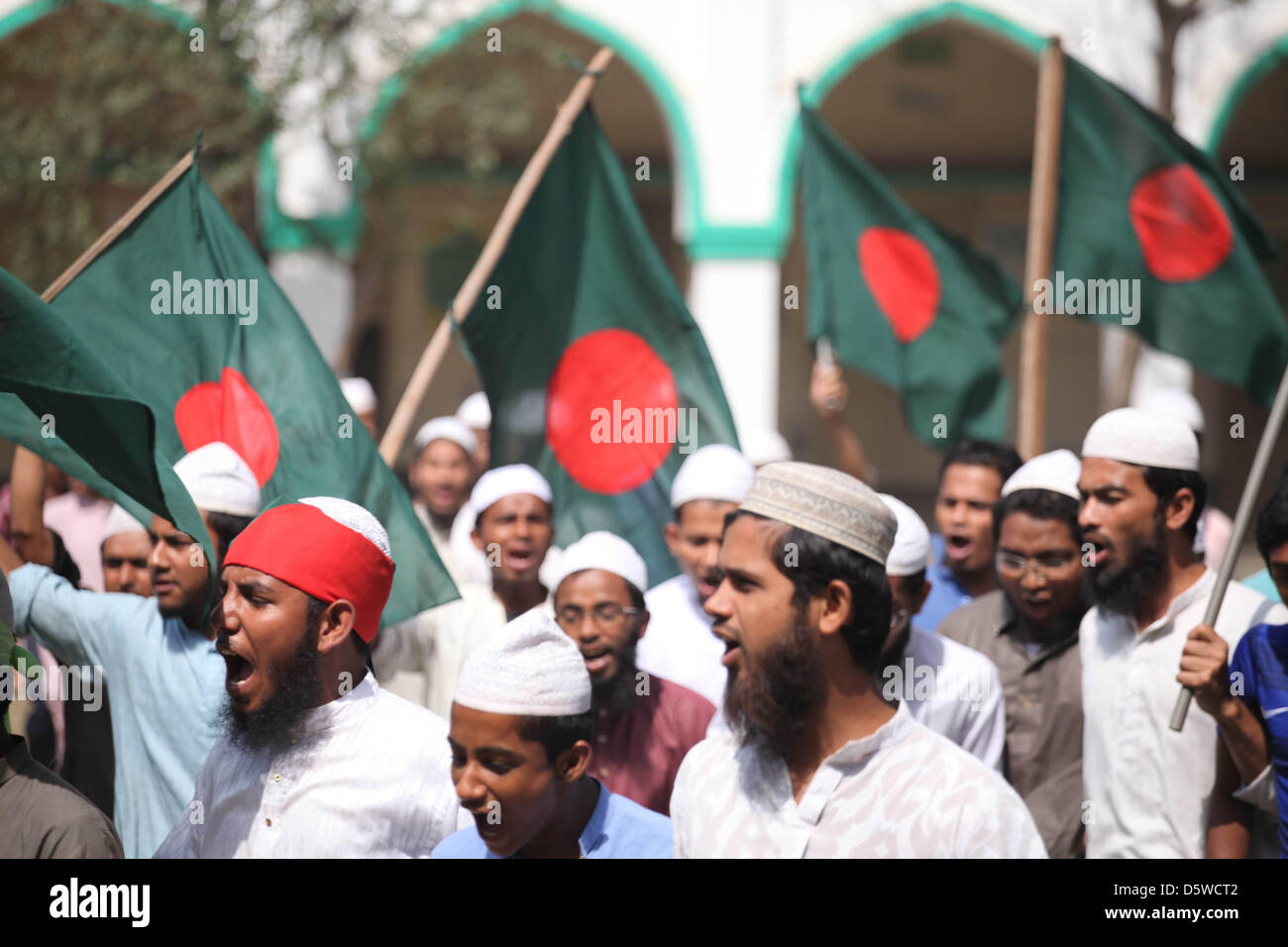 Hefazot-ich-Islam-Parteimitglieder und Unterstützer im Bild wie sie Fahnen schwenken und Parolen schreien, während die Unterstützung von einem landesweiten Streik bei Kamrangirchar in der Hauptstadt Dhaka, 8. April 2013. Ein landesweiter Streik von Hefajat-e-Islam gefordert, Bestellung, zu wiederholen, eine Reihe von Anforderungen und drücken für die Testversion eines atheistischer Blogger gefordert. Stockfoto