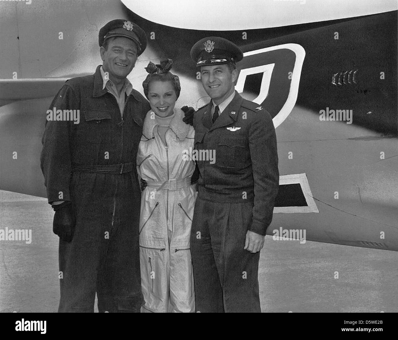 John Wayne, Janet Leigh und Lieutenant Col. Fred J. Ascani posieren am Drehort des Howard Hughes-Films Jet Pilot. Der Film mit Szenen aus der Luft- und Militärluftfahrt wurde während der Ära des Kalten Krieges produziert. Stockfoto