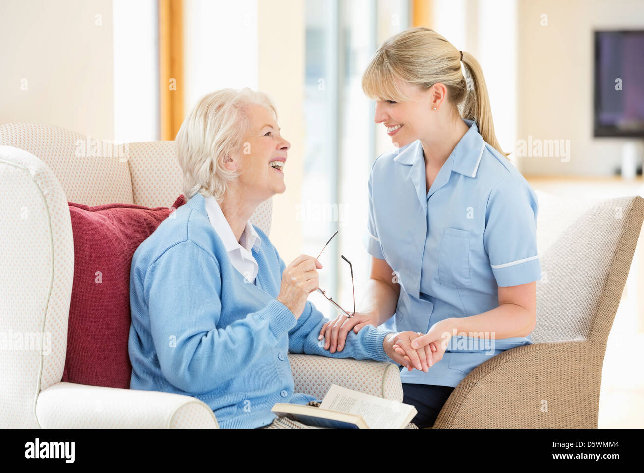Betreuer im Gespräch mit älteren Frau Stockfoto
