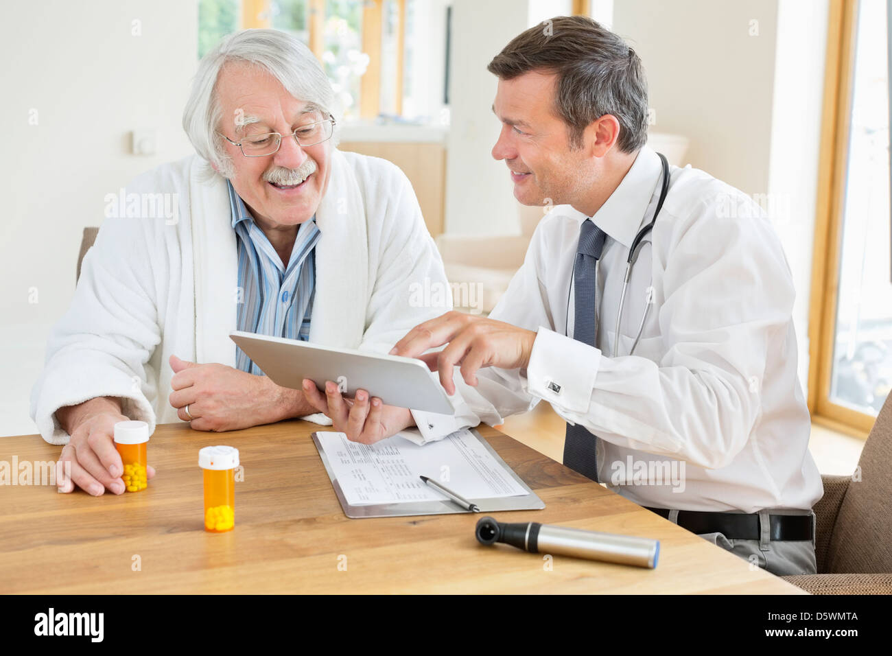 Arzt im Gespräch mit älteren Patienten im Hausbesuch Stockfoto