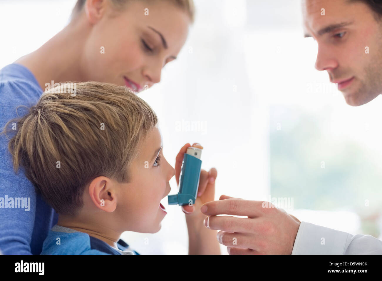 Eltern geben Sohn Asthma-Inhalator Stockfoto