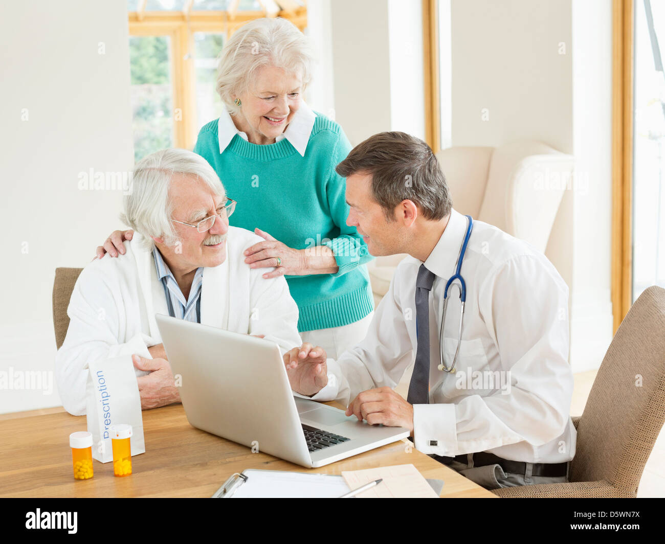 Arzt im Gespräch mit älteren Patienten im Hausbesuch Stockfoto