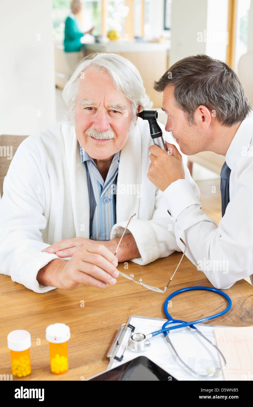 Arzt Untersuchung älterer Mann Ohr auf Hausbesuch Stockfoto