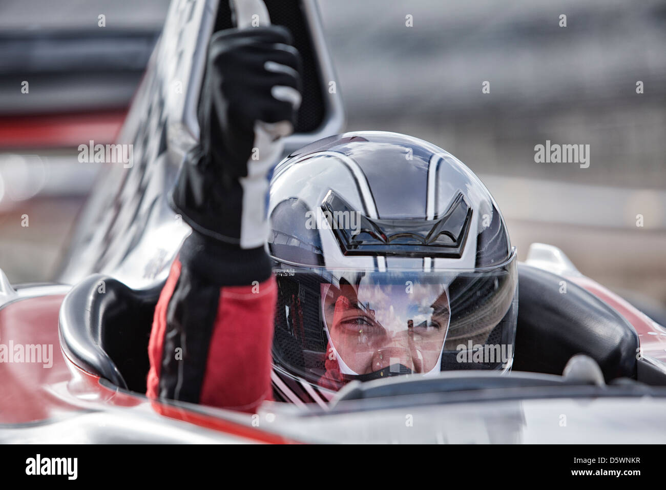 Racer Daumen aufgeben von Car auf der Strecke Stockfoto