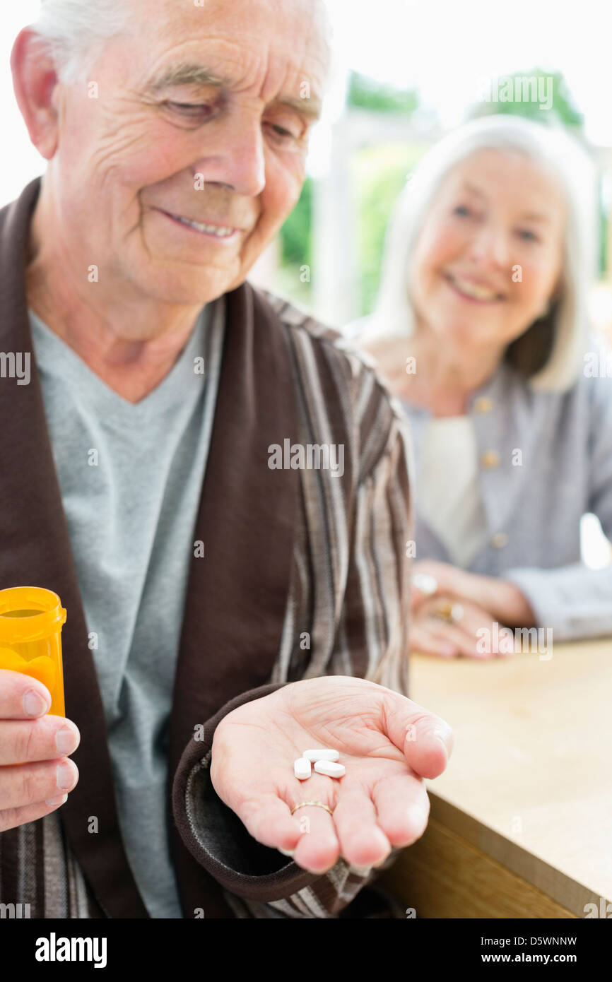 Älterer Mann mit Handvoll Pillen Stockfoto