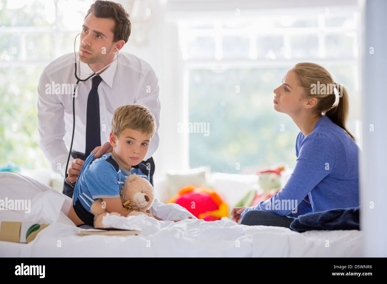 Arzt anhören des jungen Herzschlag auf Hausbesuch Stockfoto